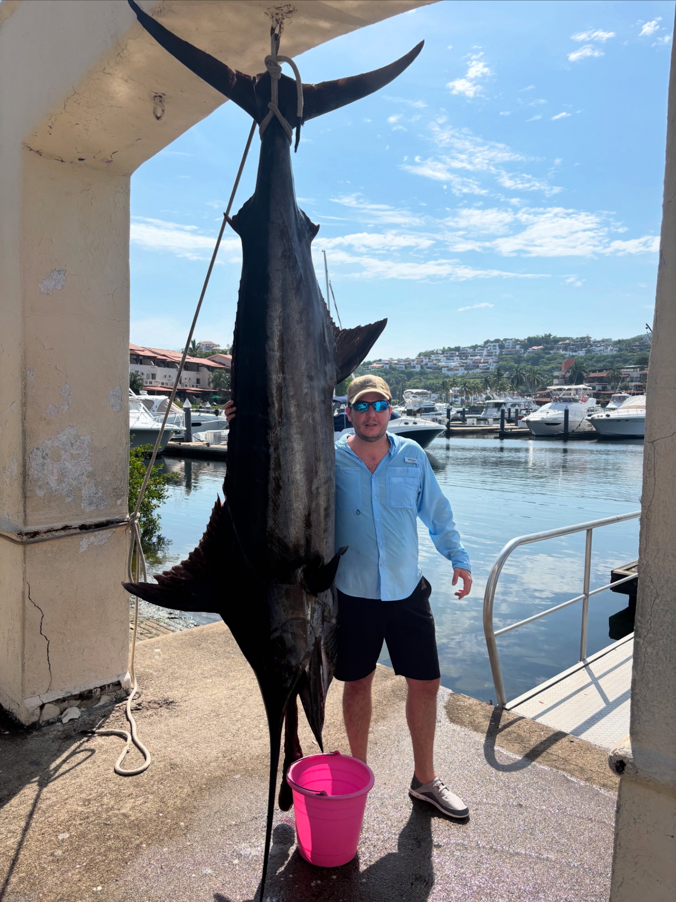 Angler with a giant black marlin at the marina