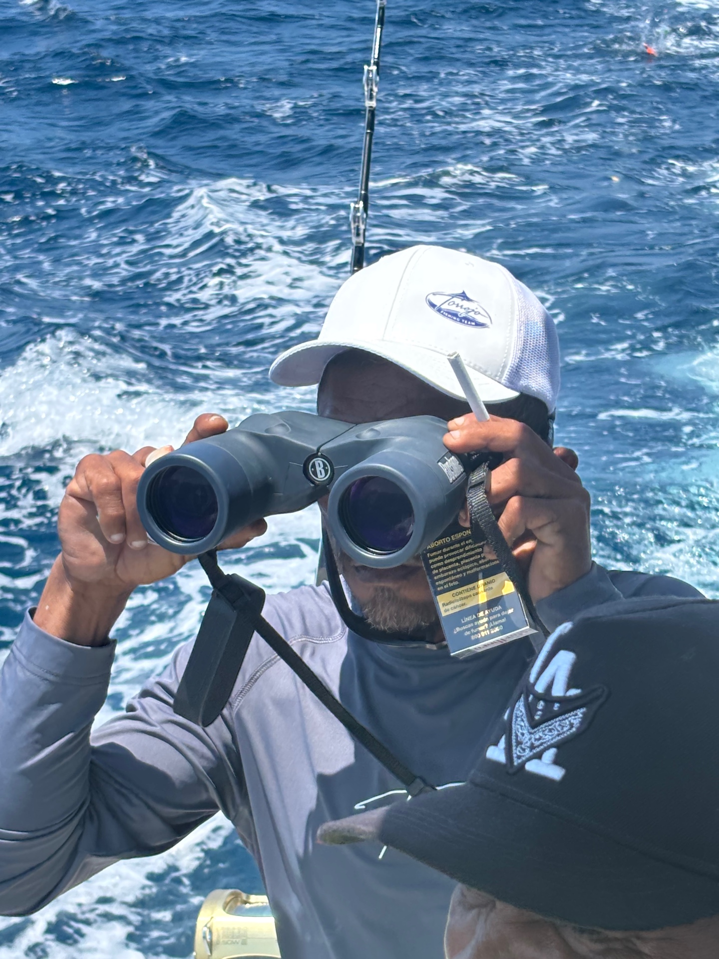 Mate scanning the water with binoculars for birds and bait